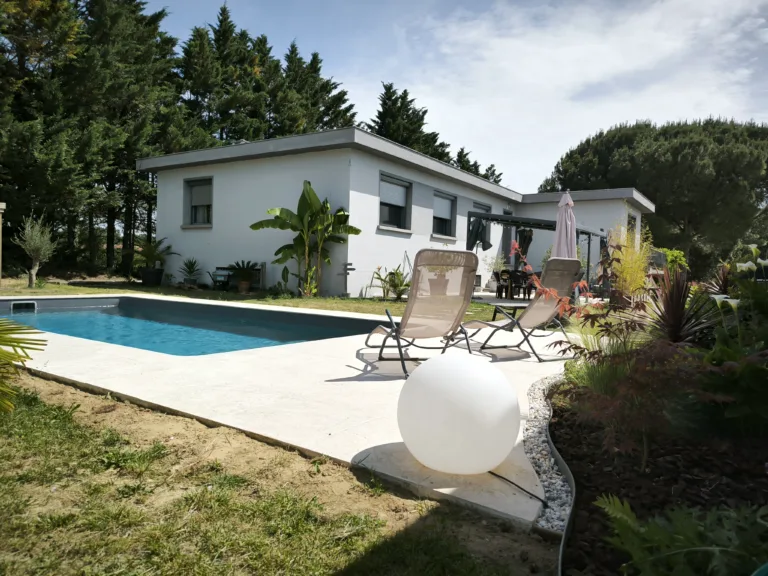 Maison moderne avec volets roulants intelligents IMACT et piscine extérieure, bénéficiant d'une gestion automatique du confort.